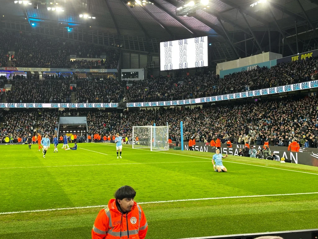 Phil Foden feirer skliende på Etihad matta etter sin 3-1 scoring. 